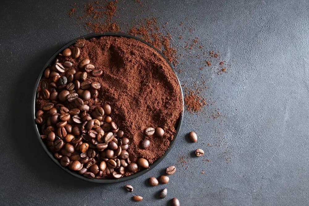 Café molido con granos alrededor